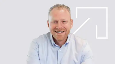 Bosch associate Bernhard Gijzen sitting cross-legged in front of the Bosch logo at the Nieuwegein location.