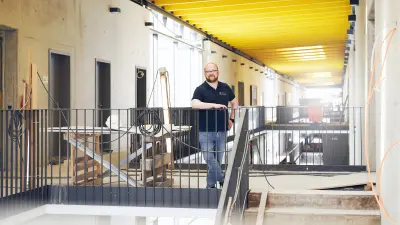Marco Krause stands on the railing with yellow ceiling in the background