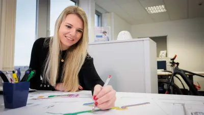 Sabrina Ruis sits at her desk with a pen in her hand