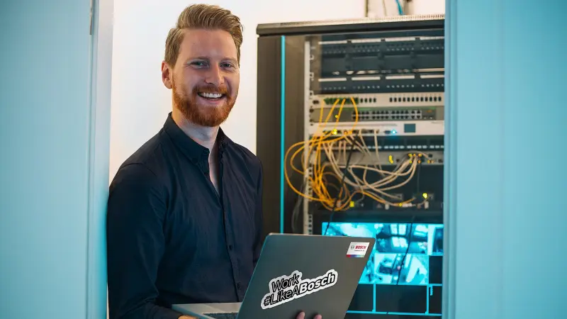 Lachender Bosch-Techniker im Server-Raum