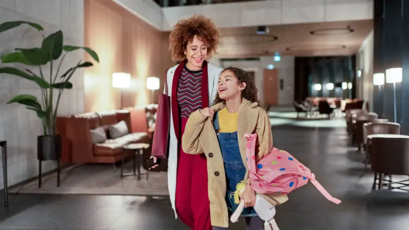 Hochhäuser mit Glasfassaden daneben unterhalb zwei Personen auf einer Dachterasse