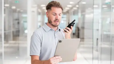Mann mit Tablet und Funkgerät in der Hand
