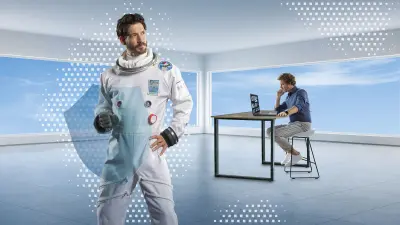 Mann im weißen Raumanzug hält ein transparentes blaues Schutzschild, im Hintergrund arbeitet ein Mann in einem modernen Büro am Laptop .