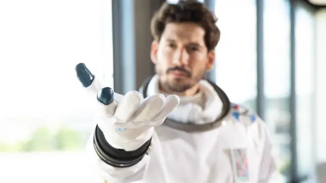 Datanaut stretching out hand their hand with the palm upward to the observer – as visualization of the creation of building digital twins with Building Digital Twins