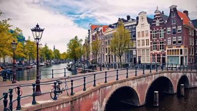Amsterdam canal with historic buildings and a brick bridge