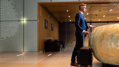 Mann mit Koffer an einer Hotelrezeption