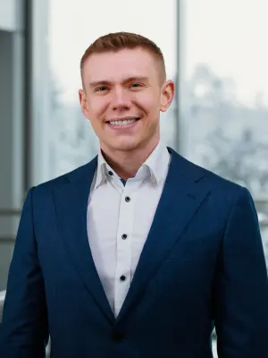 Branchenmanager Thomas Jörg steht im Anzug angelehnt an einem Geländer.