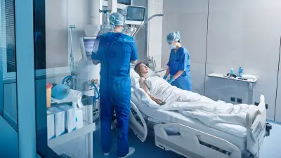 Krankenschwester und Krankenpfleger am Bett einer Patientin in der Intensivpflege