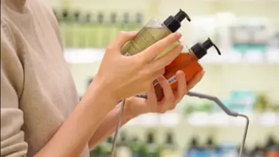 Frau in Drogerie mit zwei Shampoo Flaschen in der Hand