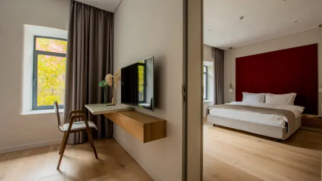 Modernes Hotelzimmer mit zwei Zimmern, Schreibtisch und Bett