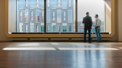 Männer an Glasfront: Bosch Building Technologies ist der zuverlässige Partner zahlreicher Branchen