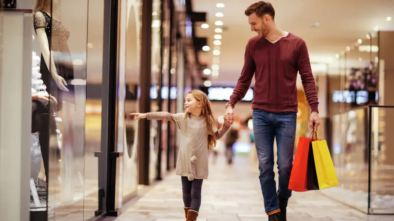 Vater und Tochter machen einen Schaufensterbummel in einem Einkaufszentrum