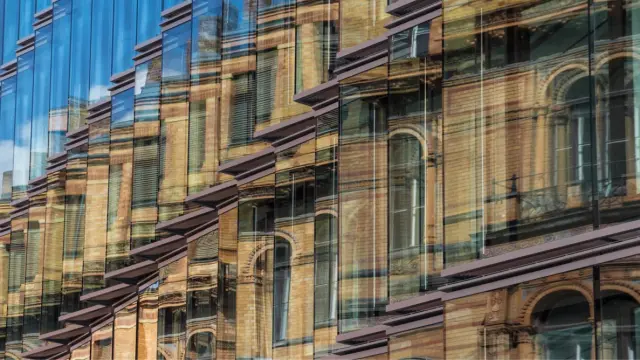 Spiegelung eines Gebäudes in der Glasfassade eines anderen Gebäudes