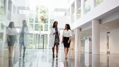 Eine Ärztin und eine Frau laufen durch ein Krankenhaus