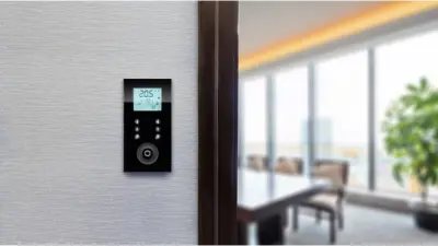 Raumcontroller hängt in einem Besprechungsraum an der Wand zur Bedienung der Raumautomation