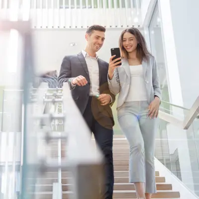 Lächelnde Frau steht in einem Büro. Perfekte Umgebungsbedingungen in Räumen sorgen für zufriedene Mitarbeiterinnen und Mitarbeiter