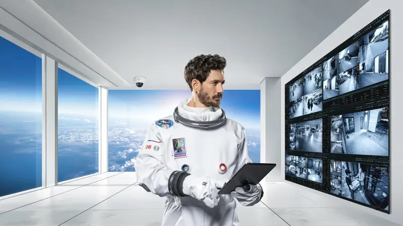 NEXOSPACE Datanaut-Astronaut überwacht digitale Brandschutzsysteme in futuristischem Kontrollzentrum mit Videoüberwachung.