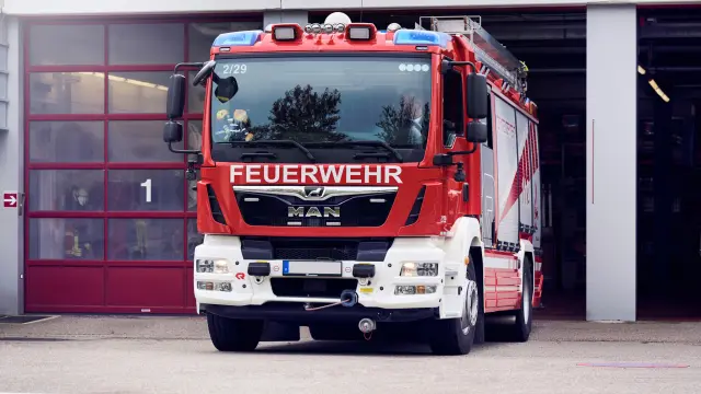 Vor Fahrzeughalle steht ein Feuerwehrauto