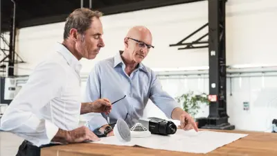 Zwei Männer planen eine Brandmeldeanlage für den analgentechnischen Brandschutz