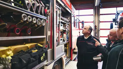 Feuerwehrmann und Brandschutzexperte sehen sich die Gerätschaften in einem Feuerwehrauto an. 