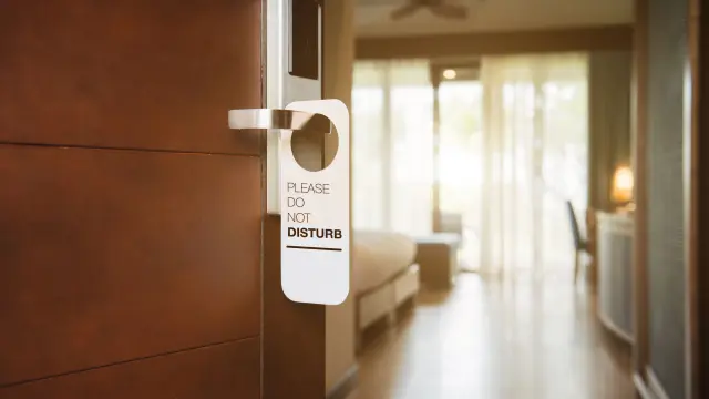 Offene Zimmerstür mit Bitte nicht stören Schild