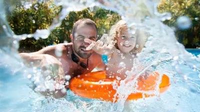 Mann und Kind spielen im Hotelpool