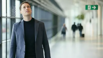 Innenansicht eines öffentlichen Gebäudes mit Mann, der eine Durchsage hört