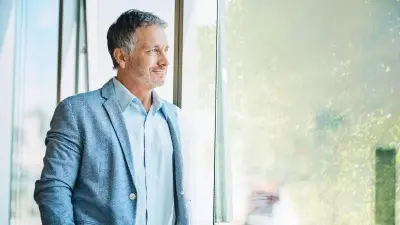 Person als Zielgruppenperson sieht aus dem Fenster, grüne Umgebung