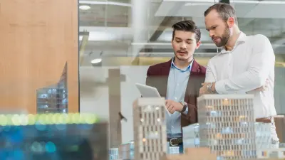 Zwei Fachplaner diskutieren Entwurf auf einem iPad