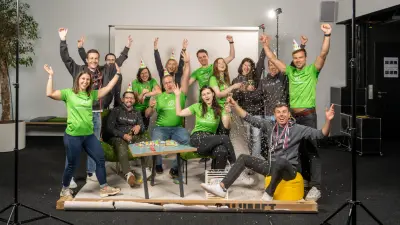 Teamfoto mit jubelnden Mitarbeitenden