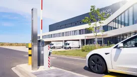 Car entering a modern industrial facility through a gate