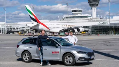 Two Bosch Building Technologies associates with their car on the apron of Munich Airport