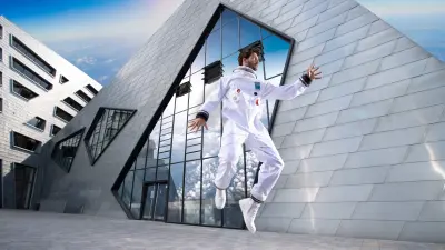 Astronaut in a white suit floating in front of a modern building