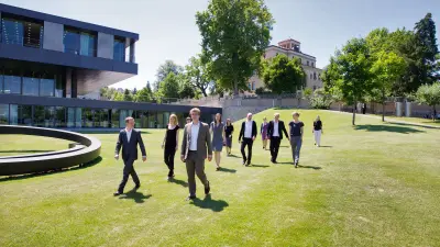 Außenansicht Robert Bosch Stiftung Stuttgart mit Haus Heidehof, Gruppe von Menschen im Garten