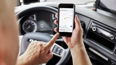 Lkw-Fahrer reserviert einen Parkplatz auf dem Autohof Frechen über die Bosch Secure Truck Parking-App.