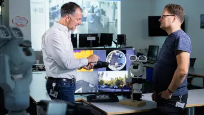 Bosch Mitarbeiter schult einen Teilnehmer zu einer Videokamera