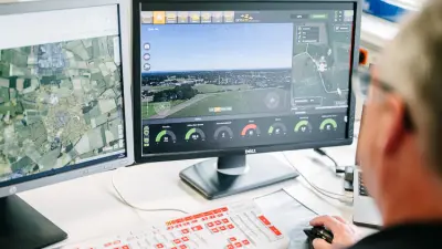 Bosch Drohnenservice, Mitarbeiter steuert Drohne im BVLOS über den Computer, Monitore