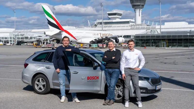 The Bosch team stands on the runway of the airport with Michael Huck from Flughafen München GmbH