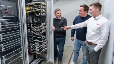 Michael Huck with the two Bosch colleagues in front of the Bosch control cabinet