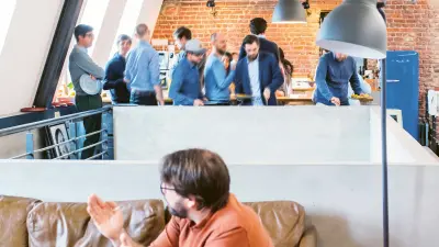 two workers holding a meeting in an open office space Kollegen 