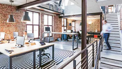 A man walking down stairs in an open office space