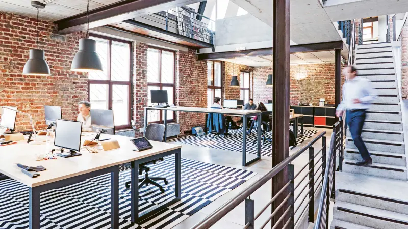 A man walking down stairs in an open office space