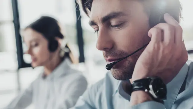 Frau mit Headset vor einem Bildschirm