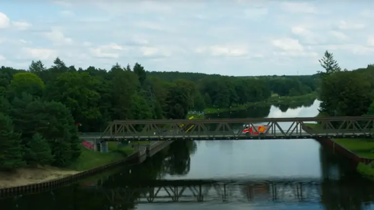 Fuerwehrfahrzeug steht auf von Wald umgebener Brücke