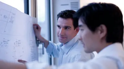 Zwei Männer planen ein Gebäude