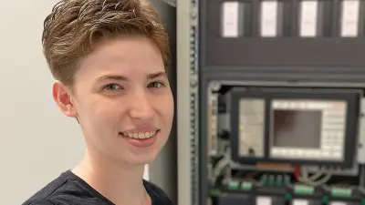 Porträt von Sabine, im Hintergrund sieht man den Schaltschrank