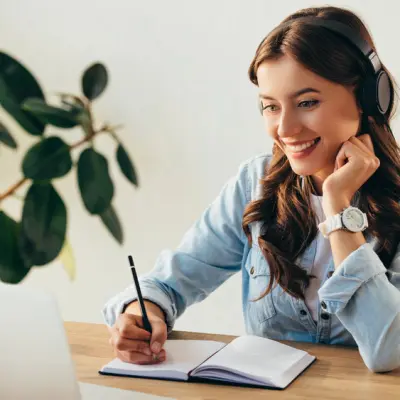 Woman with headphones looking at a laptop