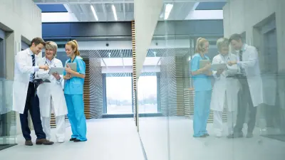 Three healthcare workers are talking in the corridor