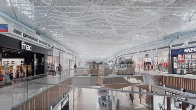 The inside of a modern shopping mall with many shops.