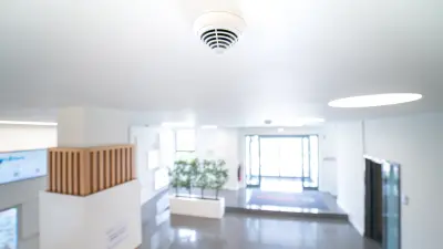 Bosch AVENAR detector 4000 overlooks the entrance and reception area of a commercial building designed in white colors and wood elements